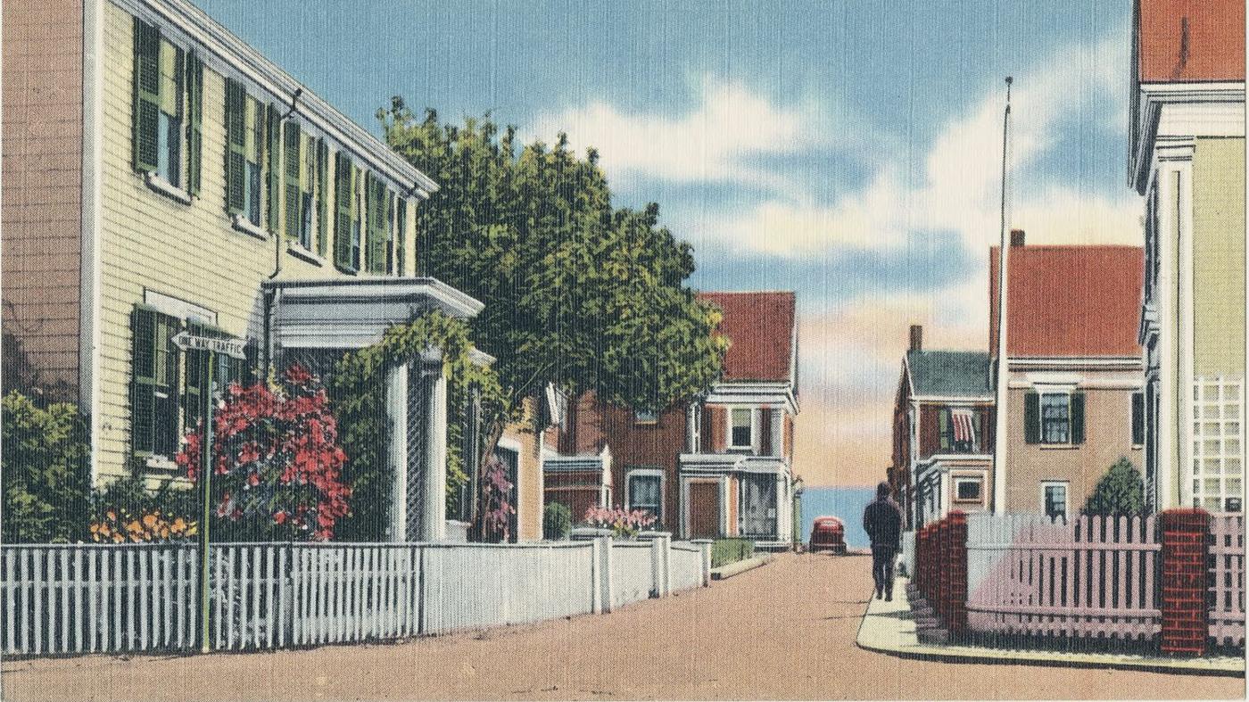 Postcard: Gosnold Street, clapboard houses with a columned porch and picket fences, the harbour at the end of the street