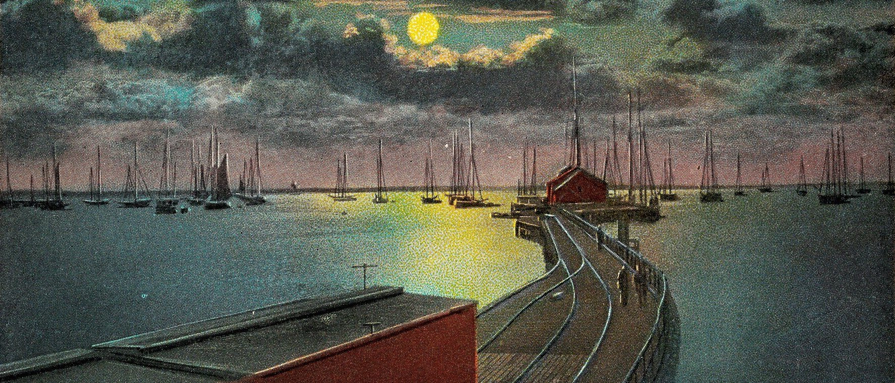 Old hand-tinted postcard: Provincetown railroad wharf by moonlight, sailboats on the harbour, a full moon over the water
