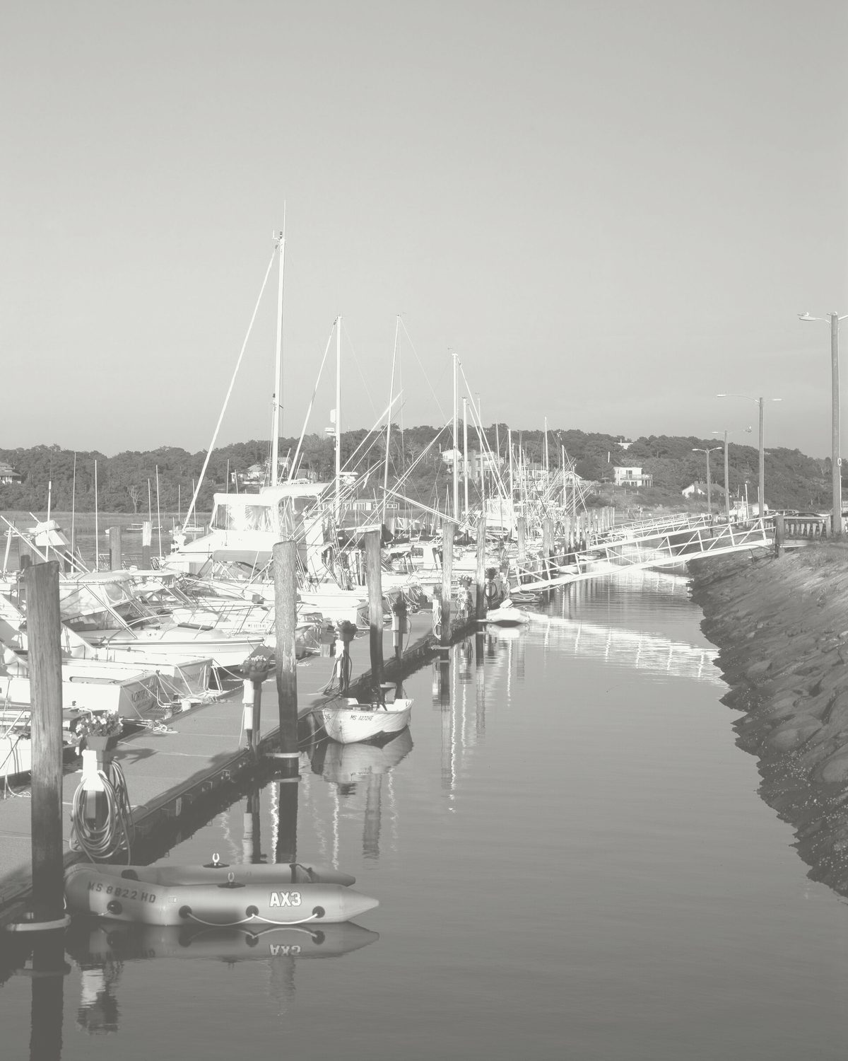 Wellfleet harbor: boats moored along a pier on still water
