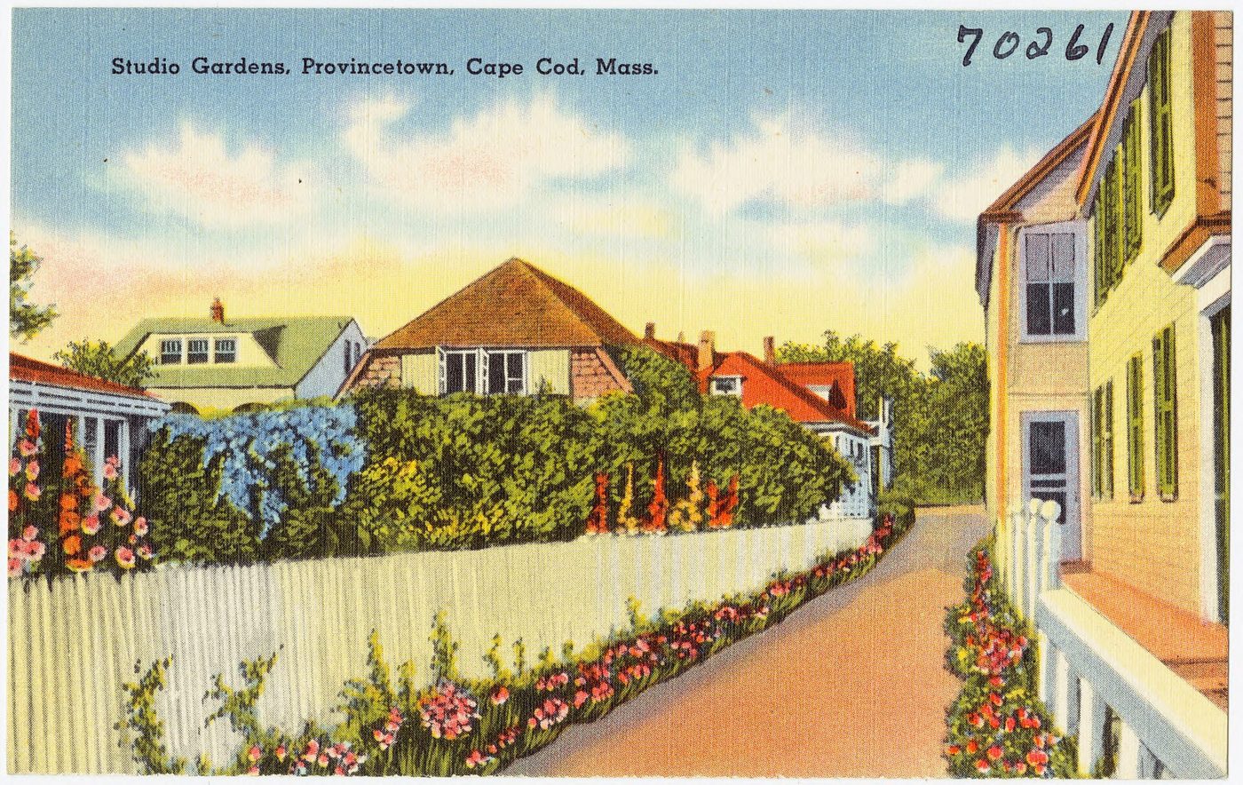 Postcard: a lane of flowering gardens and white picket fences between studio cottages.